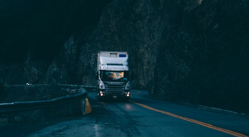 trailer truck passing on road near rail guard